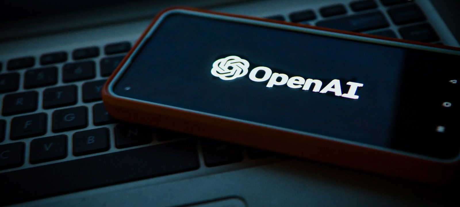 Smartphone affichant le logo d'un assistant IA posé sur un clavier